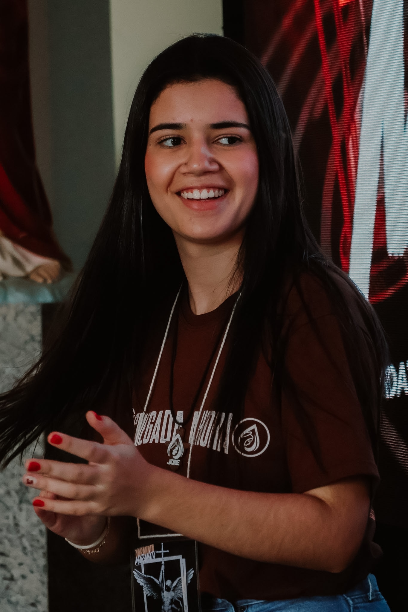 Jovem sorrindo de olhos fechados durante a oração